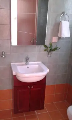 a bathroom with a sink and a mirror at Kampos Rooms in Palaiochóra