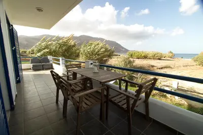 a table and chairs on a balcony with a view of the ocean at Mantilida Villa & Studio in Kissamos