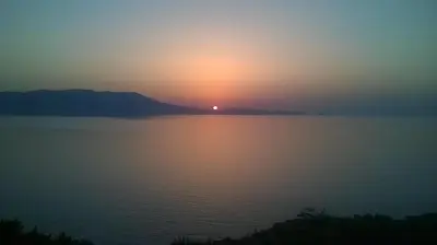 a sunset over a large body of water at Michalis Holiday Home in Ravdhoúkha