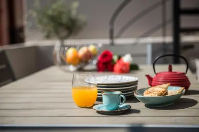 a table with a glass of orange juice and plates of food at Casa Maritima in Chania Town