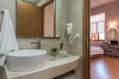 a bathroom with a large white sink in a room at Bluebell Luxury Suites in Chania Town