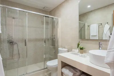 a bathroom with a shower and a toilet and a sink at Bluebell Luxury Suites in Chania Town