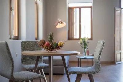 a bowl of fruit on a table with chairs at Bluebell Luxury Suites in Chania Town