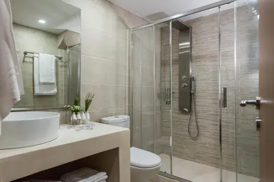a bathroom with a shower and a toilet and a sink at Bluebell Luxury Suites in Chania Town