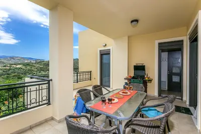 a balcony with a table and chairs and a television at Villa Selena in Stalos