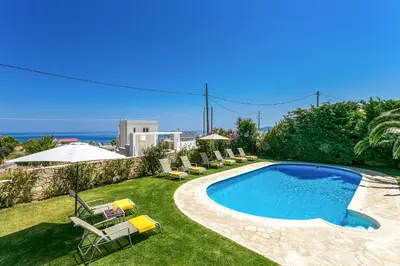 a swimming pool in a yard with lounge chairs at Villa Selena in Stalos