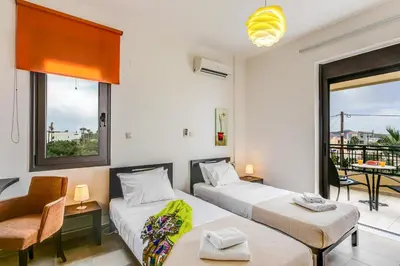 two beds in a room with a balcony at Villa Selena in Stalos