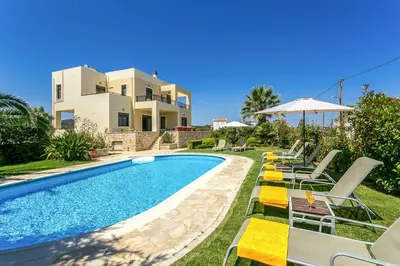 a villa with a swimming pool in front of a house at Villa Selena in Stalos