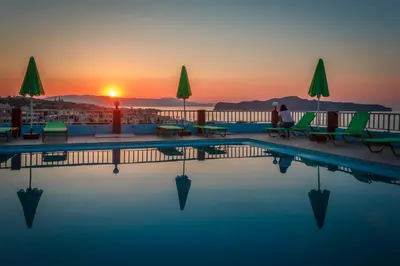 a pool with a sunset in the background at Eliros Studios in Stalos