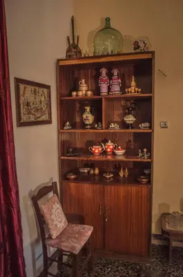 a wooden shelf with dishes and a chair in a room at Venezian Castle House in Kissamos