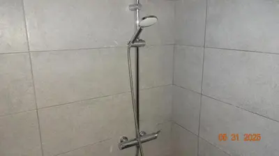 a shower with a shower head in a bathroom at Scirocco Rooms in Loutro
