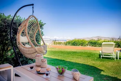 a hanging chair on a table in a yard at Lavender Villas Chania in Agia Marina Nea Kydonias