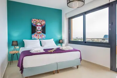 a bedroom with a large bed with a painting on the wall at Lavender Villas Chania in Agia Marina Nea Kydonias