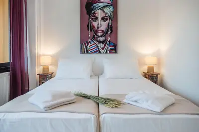a bedroom with two beds with a painting on the wall at Lavender Villas Chania in Agia Marina Nea Kydonias