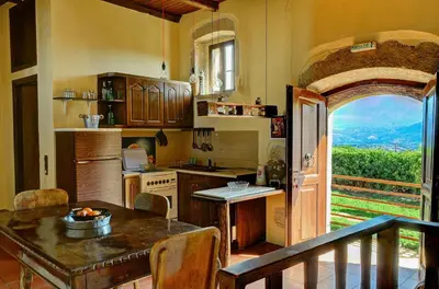 a kitchen with a table and an open door at Elia House in Megála Khoráfia