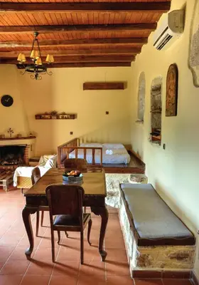 a living room with a table and a bed at Elia House in Megála Khoráfia