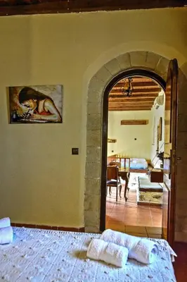 a bedroom with an archway leading to a living room at Elia House in Megála Khoráfia