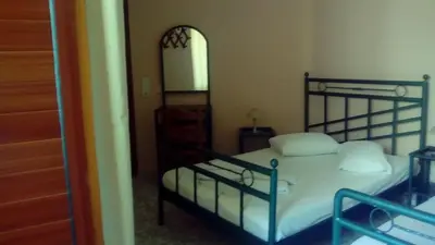 a bedroom with a bed with white sheets and a mirror at Constantinos Studios in Chania Town