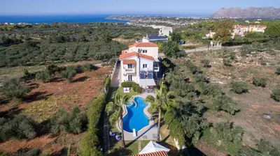 an aerial view of a large house with a swimming pool at Villa Ifigeneia Private Hot Tub Rooms in Kalathas