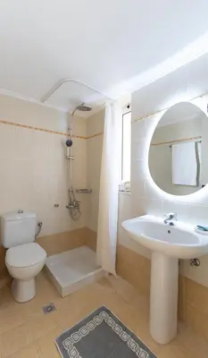 a bathroom with a sink and a toilet and a mirror at Joanna's Place in Palaiochóra