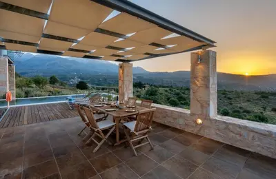 an outdoor patio with a table and chairs and a view at Kaminia Villa in Makhairoí