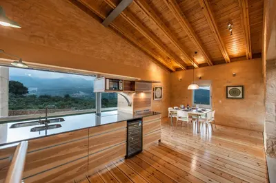 a kitchen and dining room with a large window at Kaminia Villa in Makhairoí