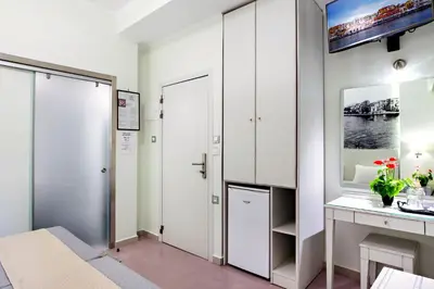 a room with a white closet and a desk at Hotel Ideon in Chania Town
