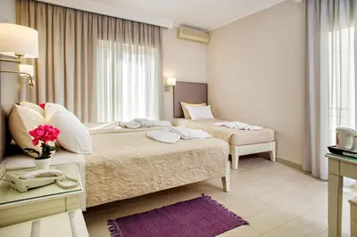 a hotel room with two beds and a window at Hotel Ideon in Chania Town