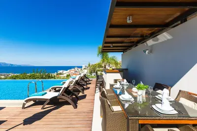 a patio with a table and chairs and the water at Winehill Villa in Plataniás