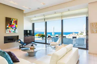 a living room with white furniture and a view of the ocean at Winehill Villa in Plataniás