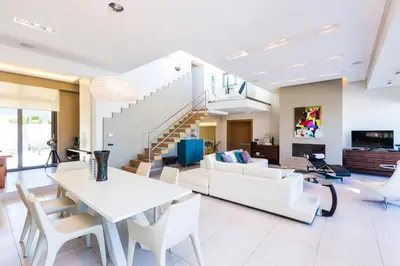 a living room with white furniture and a staircase at Winehill Villa in Plataniás