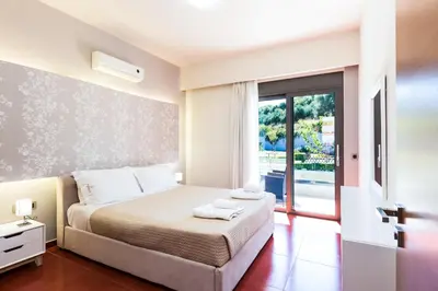 a bedroom with a bed and a large window at Winehill Villa in Plataniás