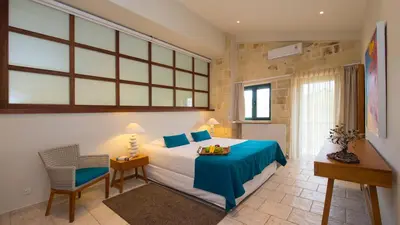 a bedroom with a bed and a table and a chair at Villa Mathea in Kounoupidhianá