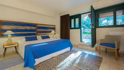 a bedroom with a blue and white bed and a chair at Villa Mathea in Kounoupidhianá