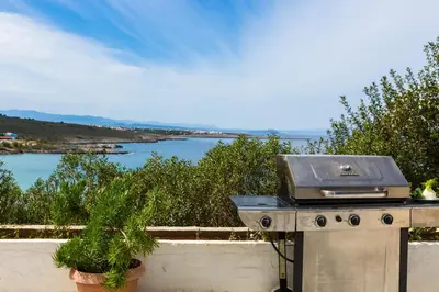 a barbecue grill with a view of the water at Kalathas Sunset Villa in Kalathas