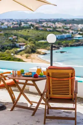 a table and chair with a table and an umbrella at Kalathas Sunset Villa in Kalathas