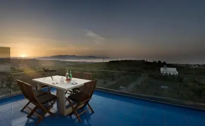 a table and chairs on a balcony with a view at Villa Emanuele in Gerani Chanion