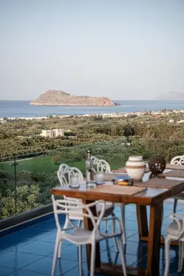 a table with chairs and a view of the ocean at Villa Emanuele in Gerani Chanion