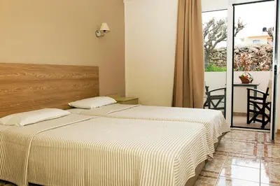 two beds in a bedroom with a balcony at Mithos Apartments in Agia Marina Nea Kydonias