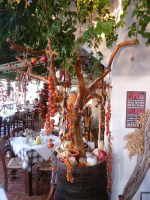 a bonsai tree in a barrel in a restaurant at Mithos Apartments in Agia Marina Nea Kydonias