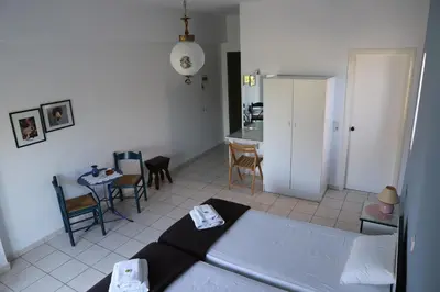 a bedroom with a bed and a kitchen with a table at Aris Apartments in Gerani Chanion