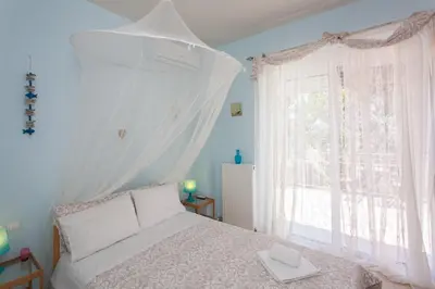 a bedroom with a white bed and a window at Cretamos Seaside Villas in Kissamos