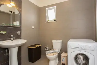 a bathroom with a washing machine and a sink at Cretamos Seaside Villas in Kissamos