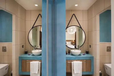 a bathroom with two sinks and two mirrors at Sea & City Apartments in Chania Town
