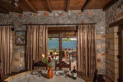 a dining room with a table and a view of the ocean at Sunset Traditional House in Ravdhoúkha