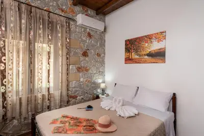 a bedroom with a bed with a hat on it at Sunset Traditional House in Ravdhoúkha