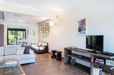 a living room with a couch and a television at Villa Ismini in Kato Daratso