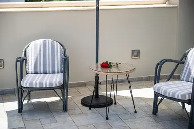 two chairs and a table with a flower on it at Villa Ismini in Kato Daratso