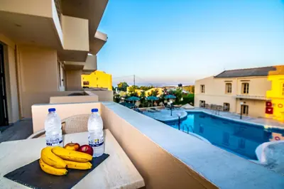 a tray of fruit on a balcony with water bottles at Orestis Hotel Sea View Apartments in Stalos