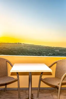 a table and two chairs in front of a window at Orestis Hotel Sea View Apartments in Stalos